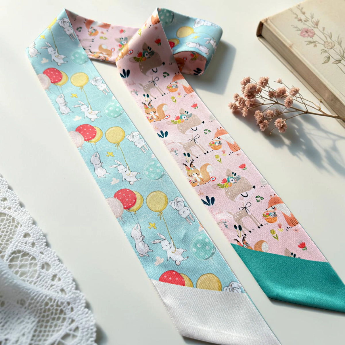 Playful rabbit twilly scarf with floating balloons and charming woodland animal illustrations on pastel blue and blush pink backgrounds.