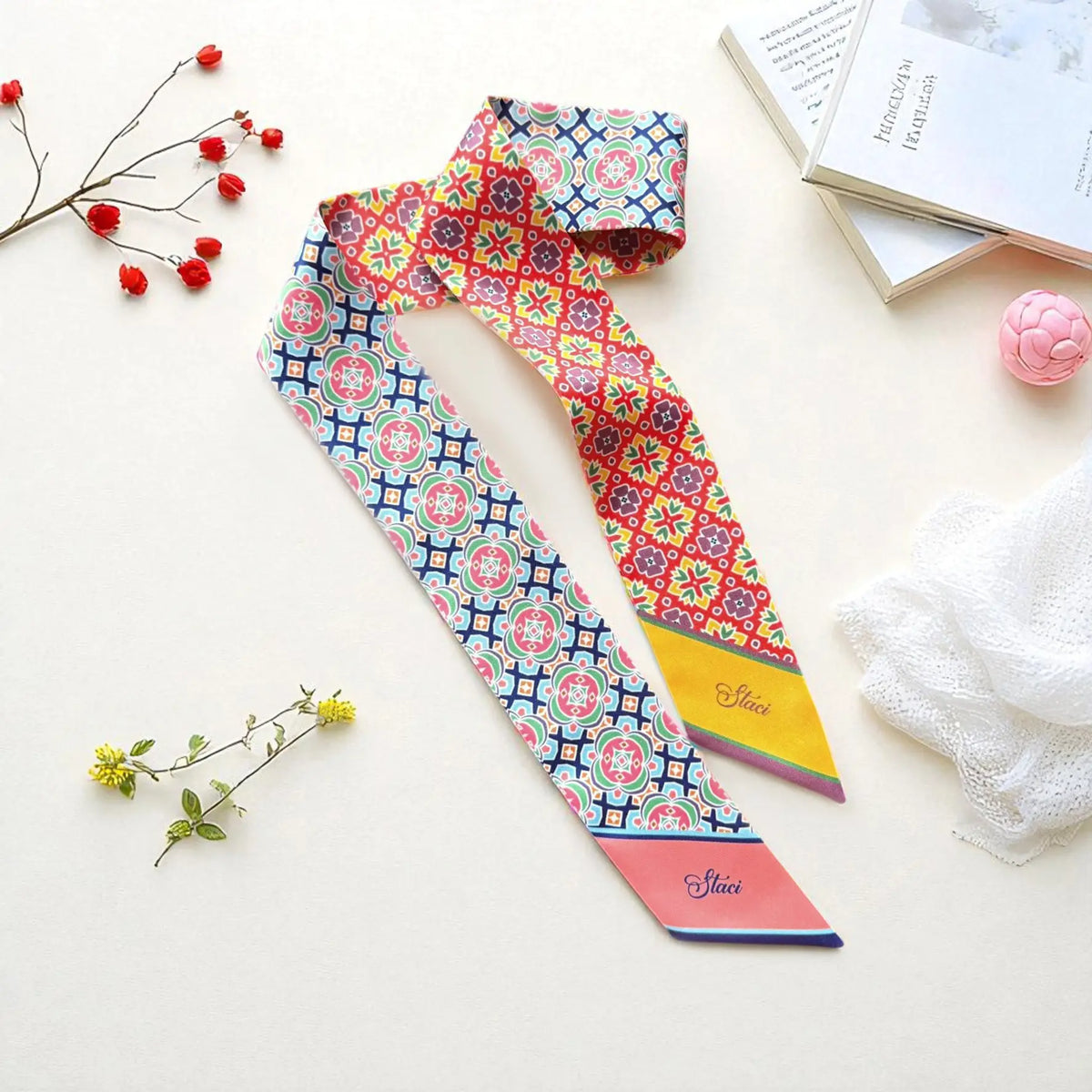Personalized twilly scarf featuring colourful batik-inspired geometric motifs in red, blue, green, pink, and yellow tones.