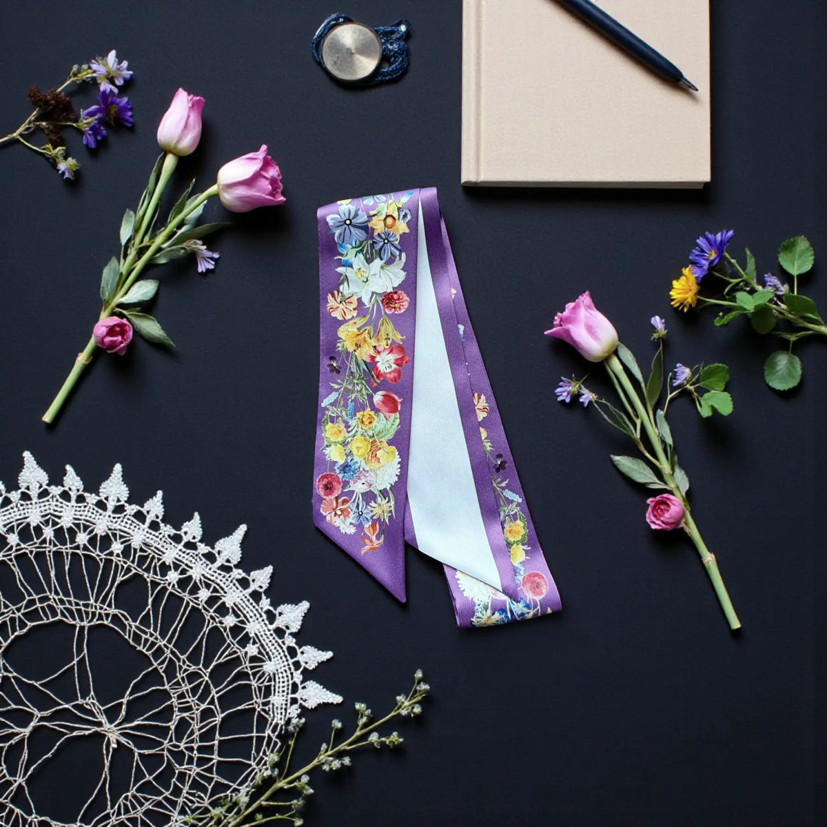 Personalised purple skinny scarf featuring vibrant floral illustrations, displayed with lavender flowers and decorative lace.