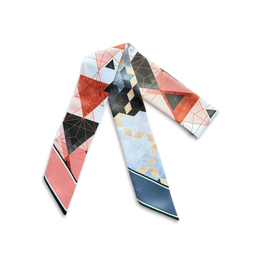 Coral pink satin skinny scarf decorated with overlapping triangles, fine geometric lines, and black and terracotta colour blocks, finished with the personalised name Julia.