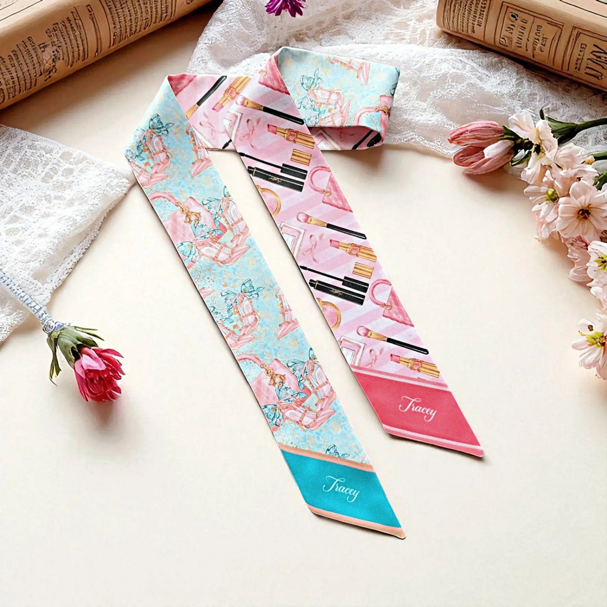 Personalized satin twilly scarves in pink and turquoise featuring beauty-inspired prints, including handbags, lipstick, perfume, and makeup accessories, finished with a custom name.
