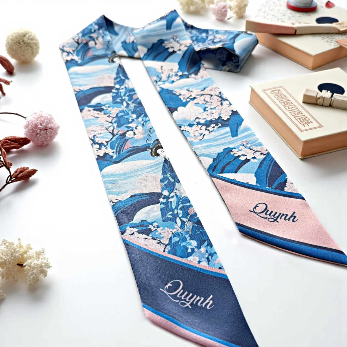 Japanese-inspired sakura twilly scarf featuring intricate floral branches, blue botanical patterns, and contrasting pink and navy personalized ends.