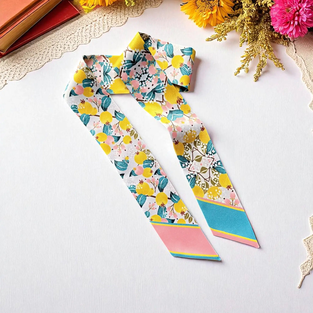 Personalized skinny scarf with colorful floral and fruit pattern in pastel tones, featuring name embroidery on silk twilly