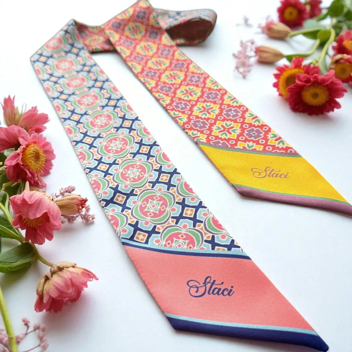 Personalized skinny bag scarf featuring vibrant geometric motifs with red and blue patterns and custom name details.