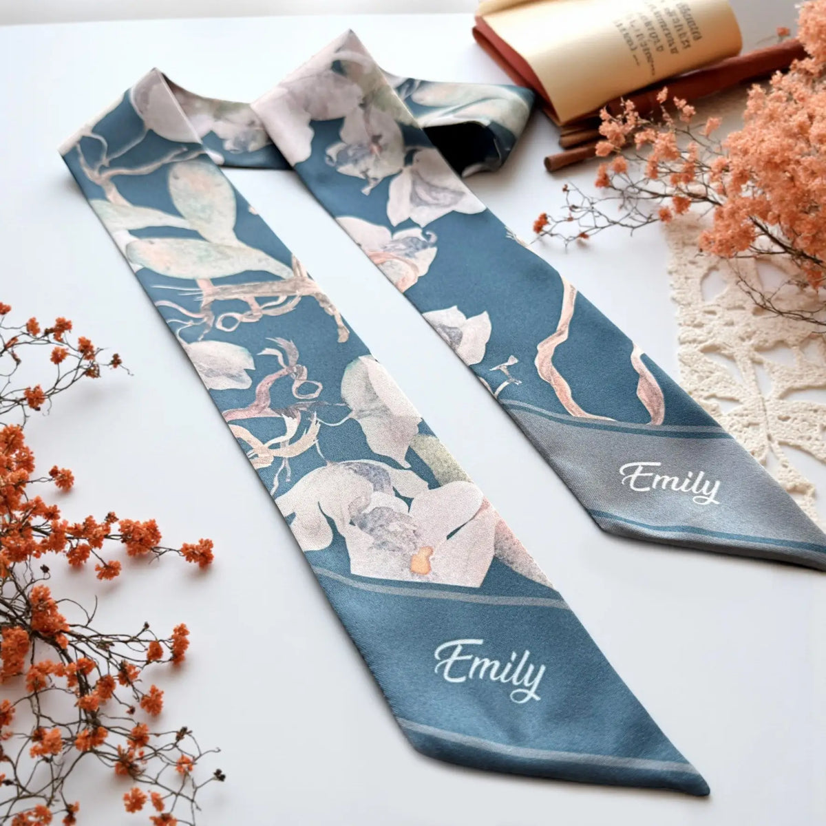 Elegant teal hair scarf with sage green leaves, soft cream flowers, and delicate botanical illustrations in a sophisticated muted color palette.