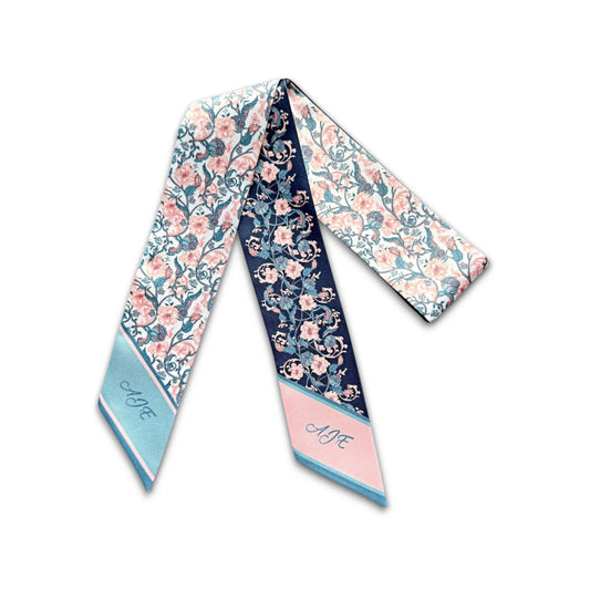 Navy blue satin skinny scarf decorated with soft pink blossoms, teal foliage, and elegant scrolling floral vines, finished with a pastel pink tip featuring personalised initials.