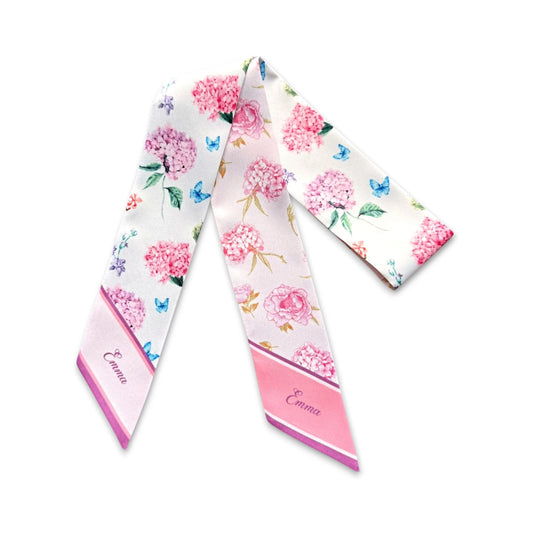 Romantic botanical skinny scarf with pink hydrangeas, garden roses, tiny blue butterflies, and green foliage on an ivory background.