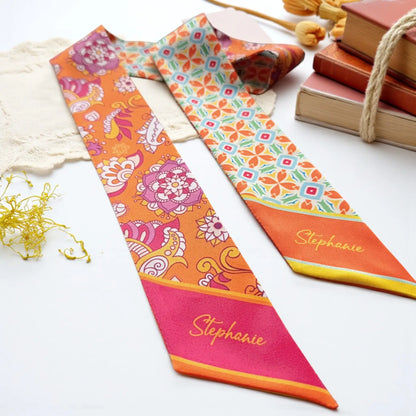 Bohemian-inspired twilly scarf combining orange paisley floral illustrations with turquoise geometric patterns and colorful retro botanical details.