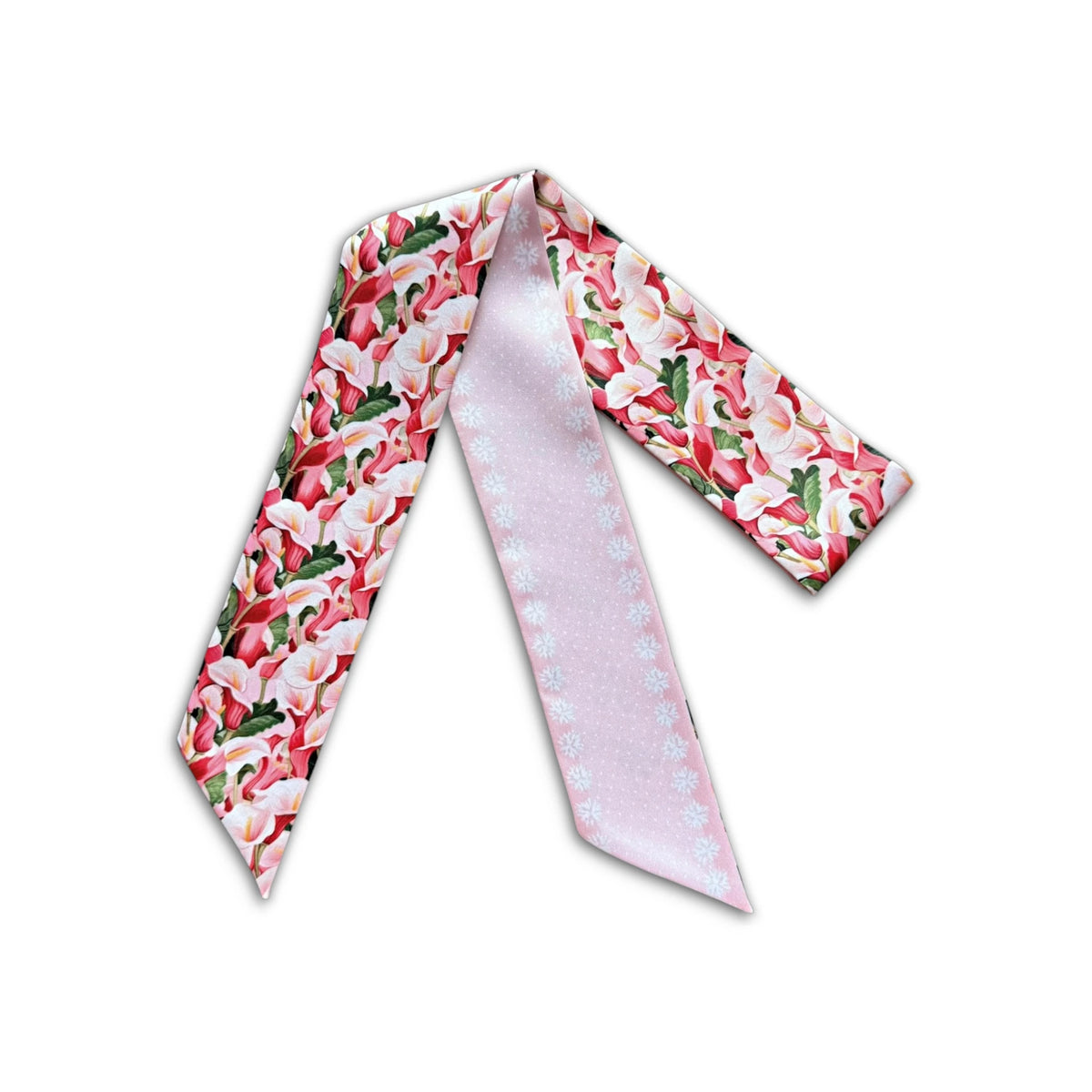 Full product view of a floral twilly scarf with colorful calla lily motifs and a contrasting pale pink side.