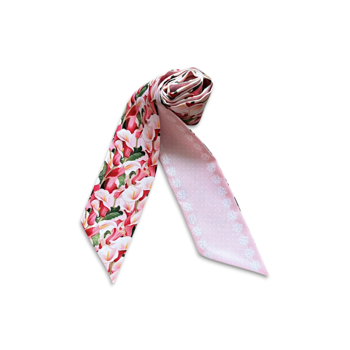 Rolled twilly scarf showing its colourful calla lily floral print and contrasting soft pink pattern.