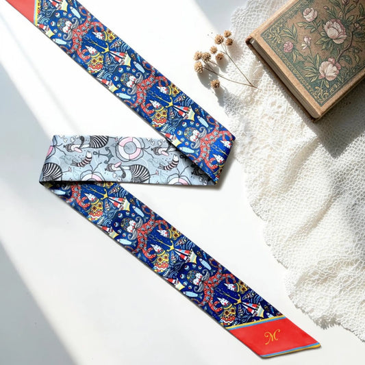 Colourful nautical twilly scarf featuring sailboats, ocean-inspired illustrations and vibrant blue, red and coral details.