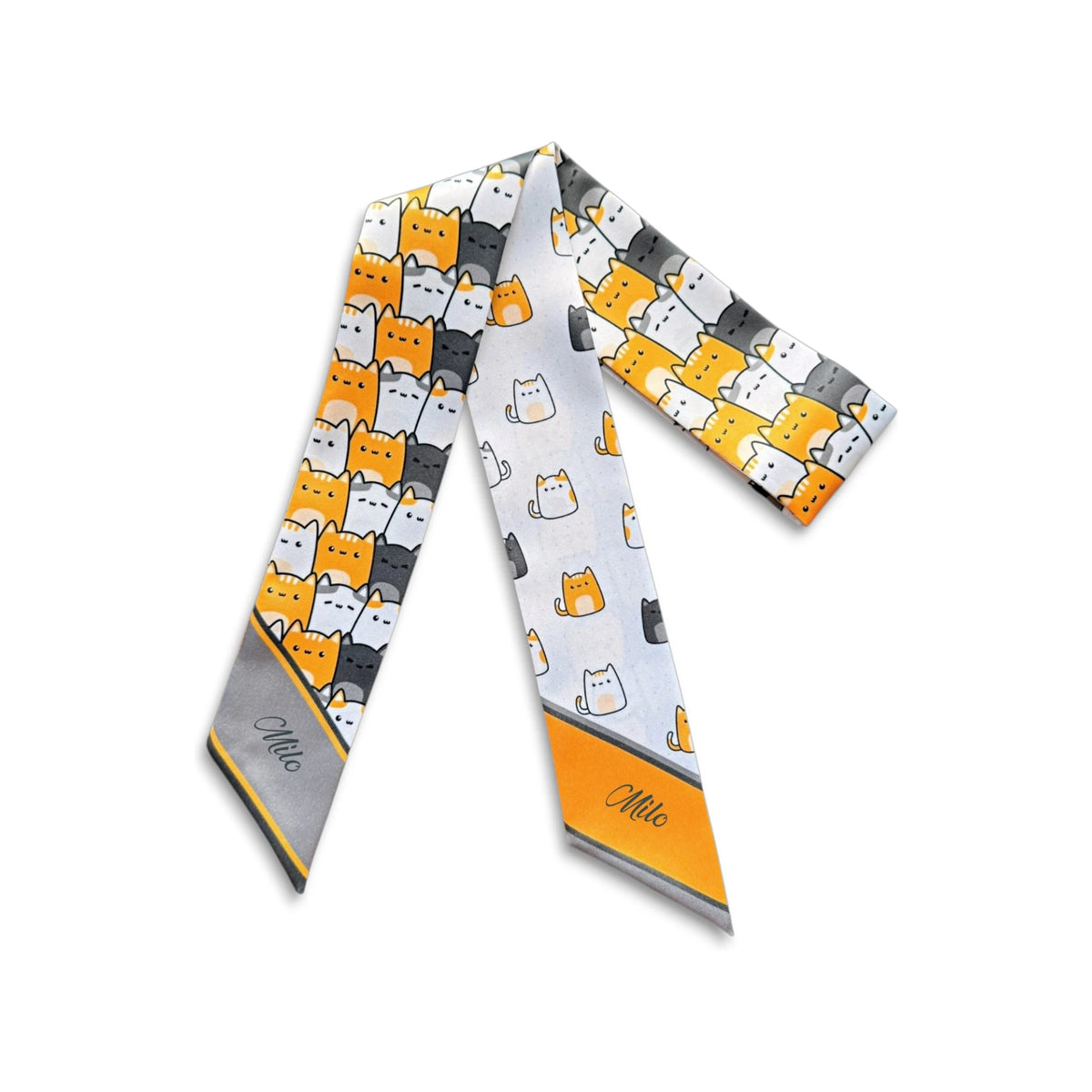 Full product view of a cat lovers twilly scarf with cartoon cats and contrasting orange and grey pointed ends.