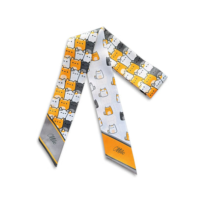 Full product view of a cat lovers twilly scarf with cartoon cats and contrasting orange and grey pointed ends.