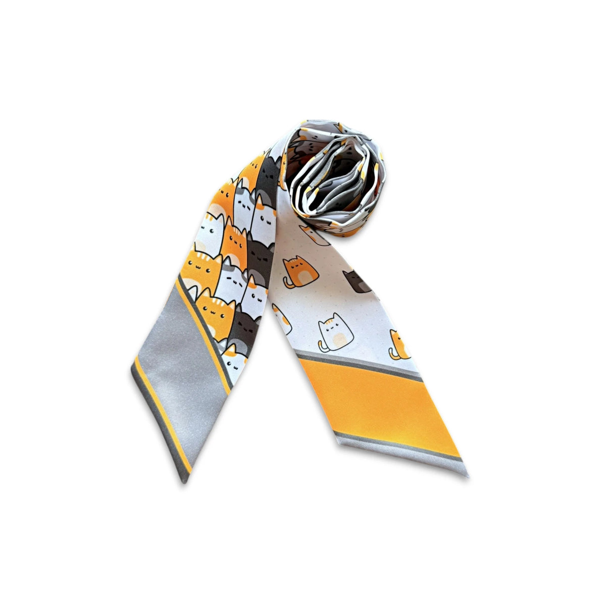 Rolled cat print twilly scarf showing its repeating cartoon cat motifs in orange, white and charcoal tones.