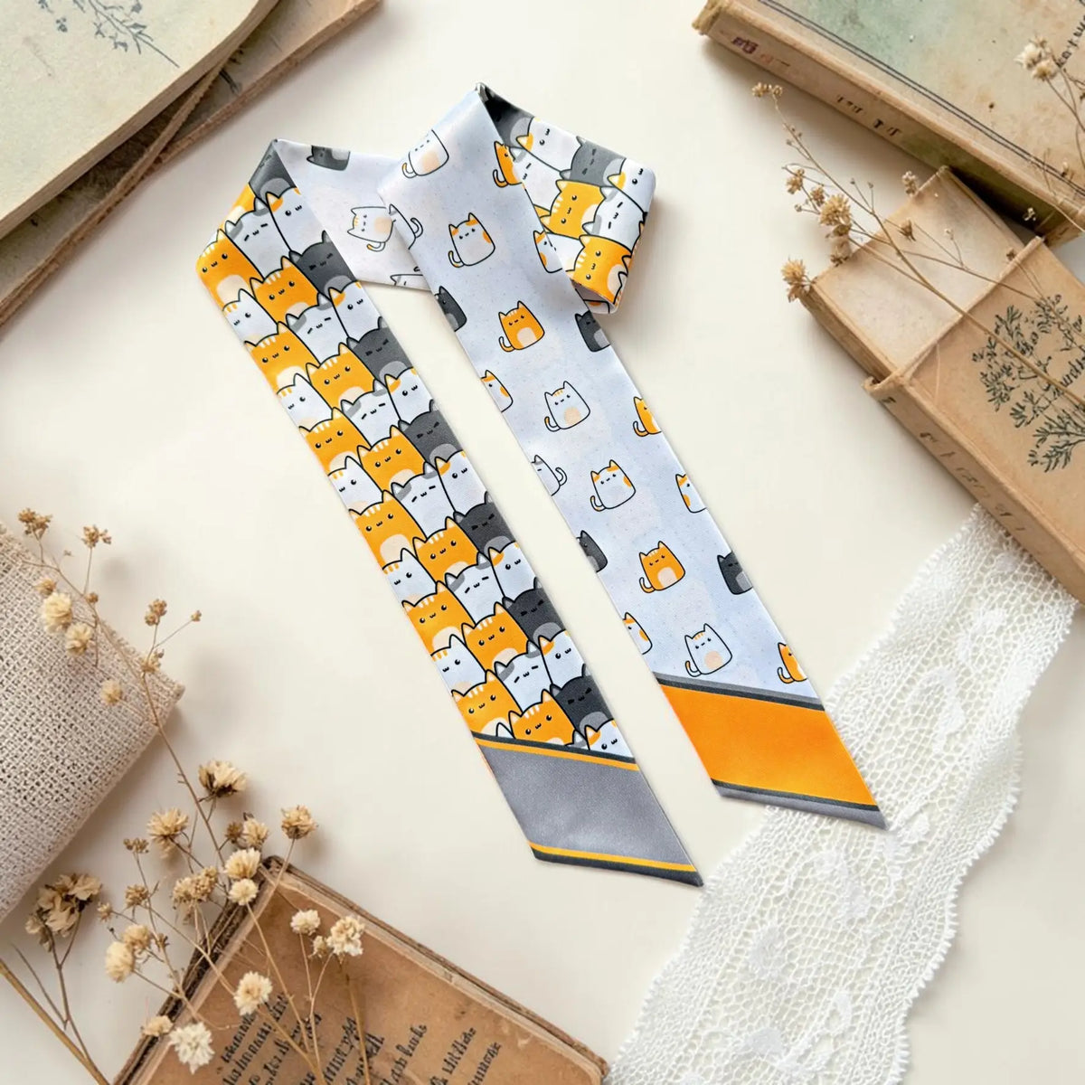 Cute cat print twilly scarf featuring playful orange, white and charcoal illustrated cats in repeating patterns.