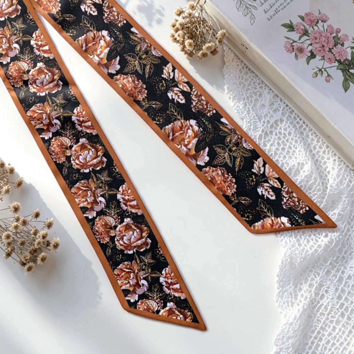 Vintage rose floral twilly scarf featuring rust and terracotta flowers on a black background with warm brown borders