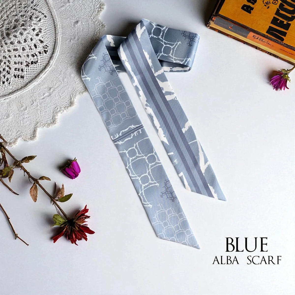 Dusty blue monochrome skinny scarf featuring delicate ivory geometric patterns and modern striped details, styled with lace and dried flowers.