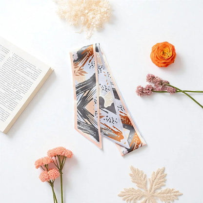 Earth-toned twilly scarf featuring contemporary floral illustrations, soft grey and beige backgrounds, peach borders, and artistic terracotta brushstroke details.