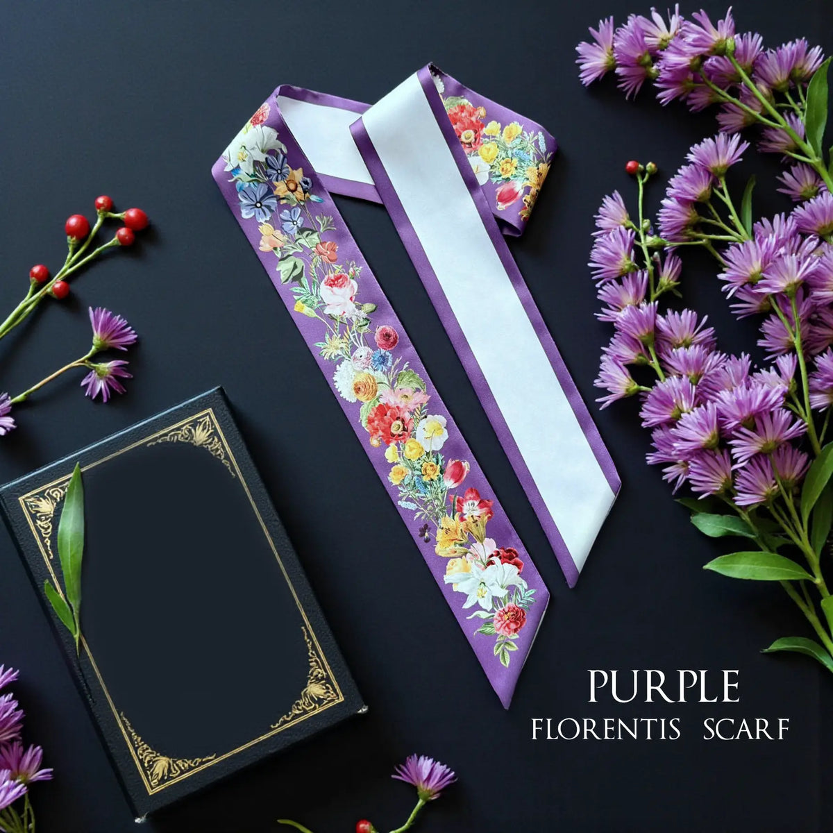 Purple personalised skinny scarf featuring colourful watercolour wildflowers and botanical details, styled beside purple daisies.