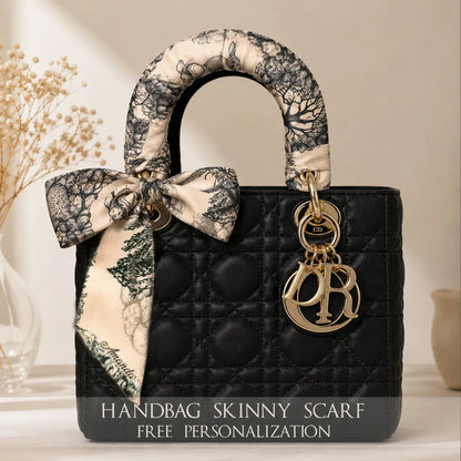 Elegant hazelnut black satin bag scarf with a  woodland-inspired print, draped over a black handbag.