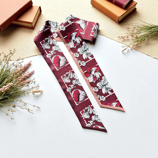 Maroon floral twilly scarf featuring large vintage botanical flowers in ivory, pink, and muted red, styled with books and dried flowers.
Photo 2