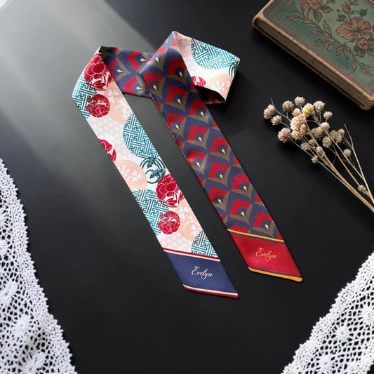 Personalized skinny scarf featuring Asian-inspired floral and geometric patterns in navy blue, deep red, turquoise, and peach, with the custom name Evelyn.