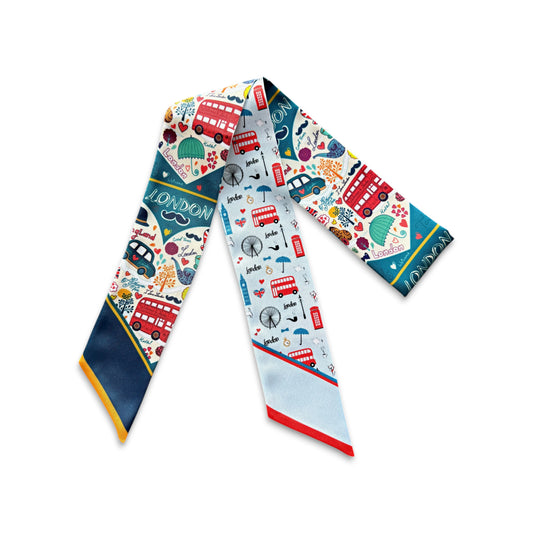 Colorful London skinny scarf featuring iconic red buses, black taxis, British landmarks, and playful travel-inspired illustrations on a light blue background.