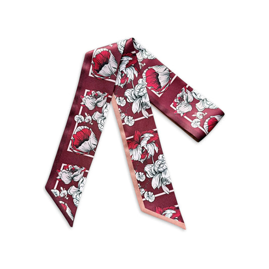 Maroon skinny scarf with bold ivory and pink floral illustrations and a contrasting blush pink reverse side, displayed on a white background.