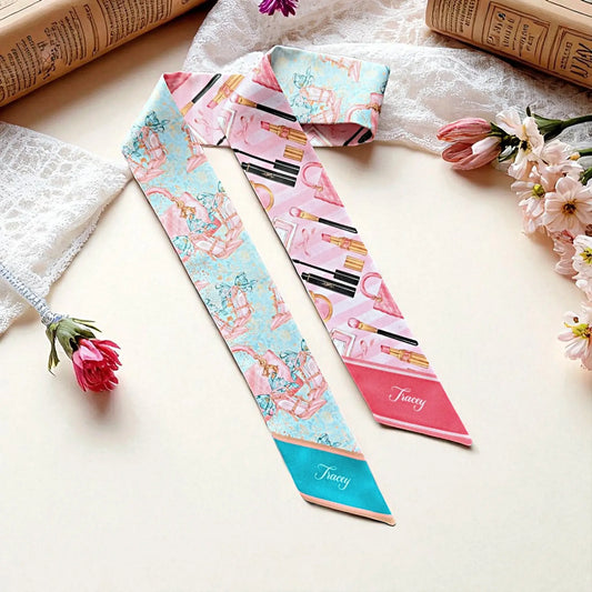 Personalized satin twilly scarves in pink and turquoise featuring beauty-inspired prints, including handbags, lipstick, perfume, and makeup accessories, finished with a custom name.