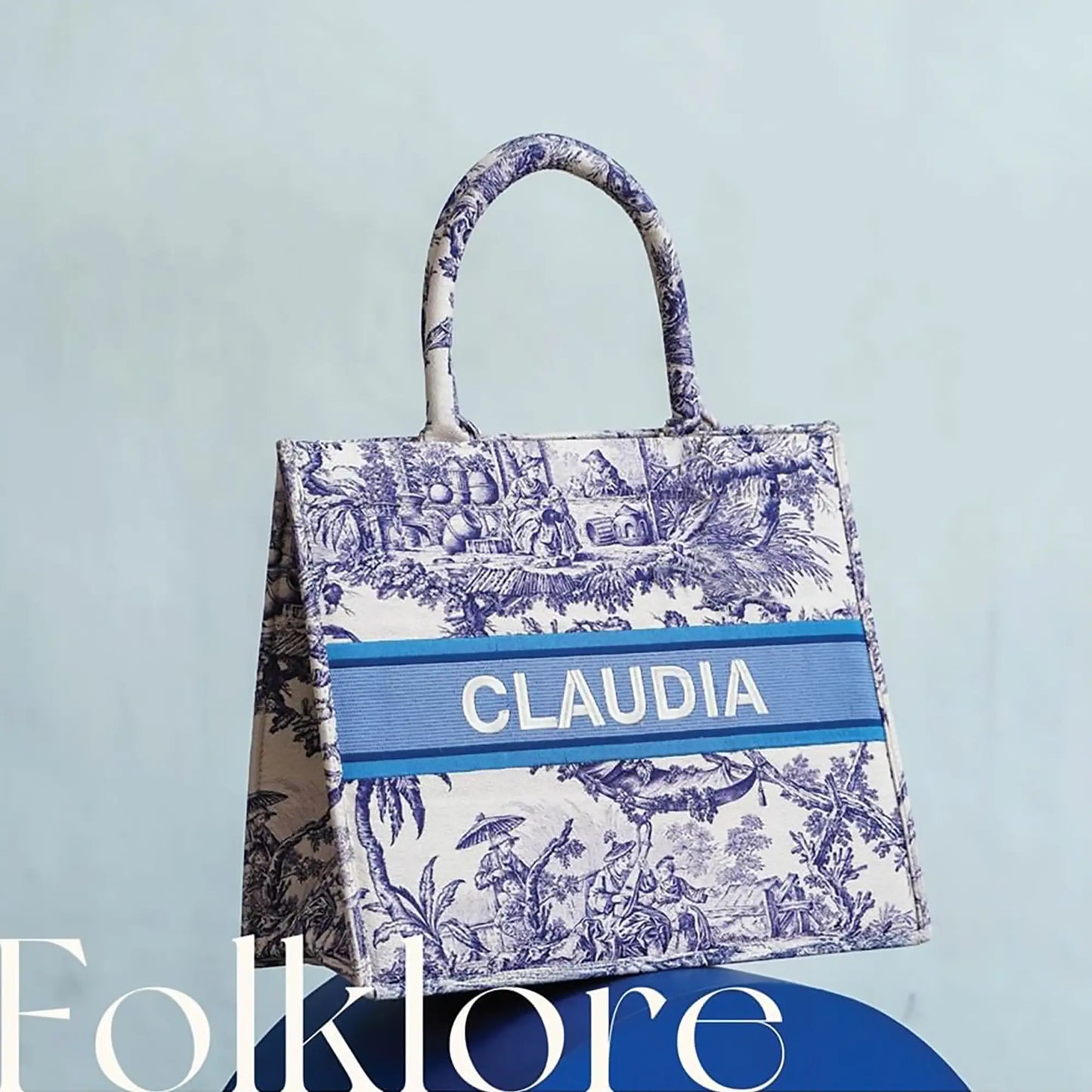 Structured personalized canvas book tote with embroidered name and blue French Toile de Jouy print.