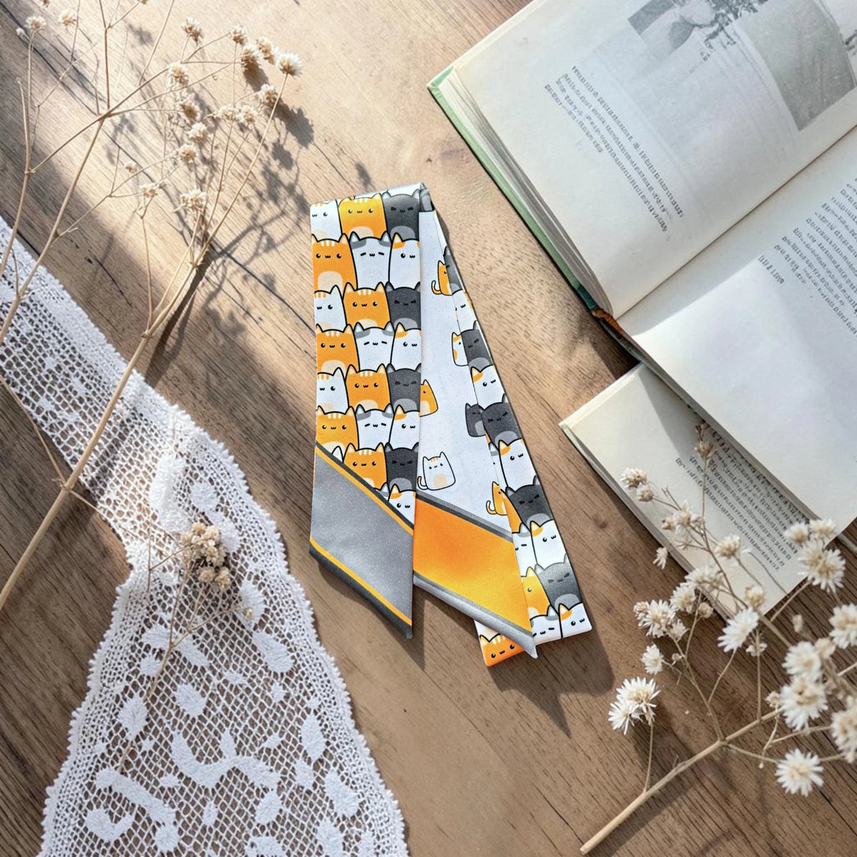 Playful cat lovers twilly scarf featuring two coordinating illustrated cat patterns with orange and grey accents.