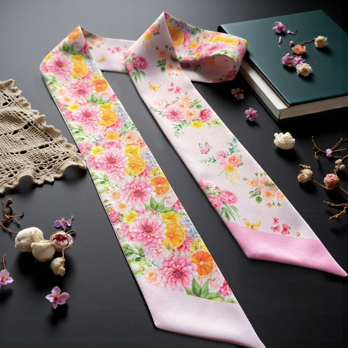 Romantic pink twilly scarf with colourful garden florals and botanical details styled on a dark background