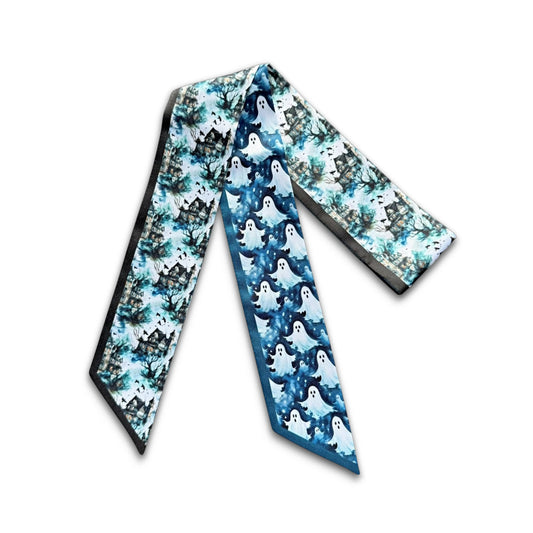Halloween skinny scarf with playful white ghost illustrations on a midnight blue background, complemented by eerie haunted house scenery.