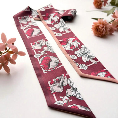 Elegant maroon twilly scarf decorated with oversized vintage flowers and a soft blush pink reverse side, arranged with delicate dried botanicals.