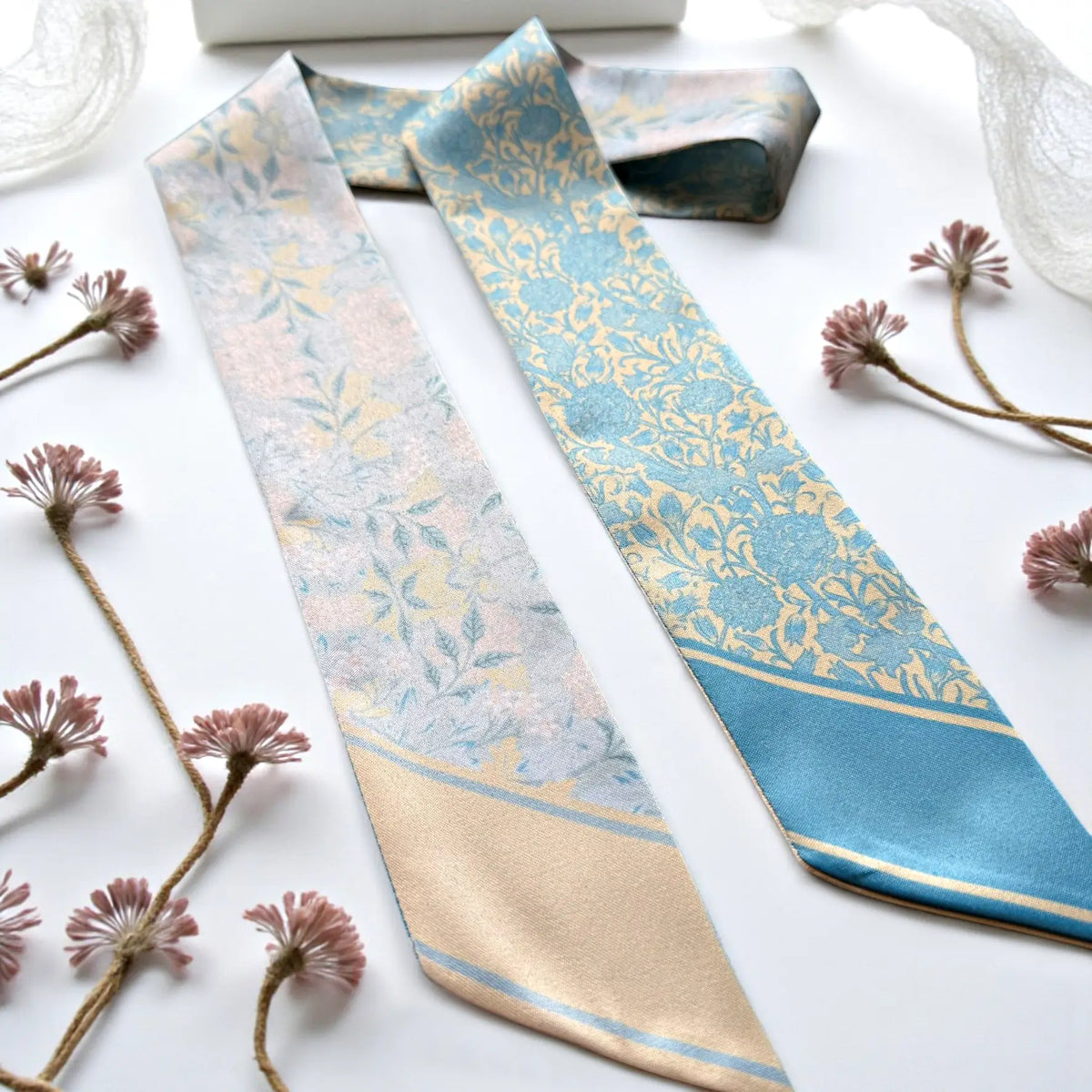Vintage floral blue and cream twilly scarf styled beside a book with delicate flowers