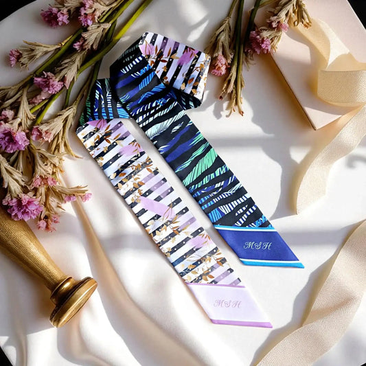 Modern double-sided skinny scarf with bold leaf print and striped design in blue and pastel palette