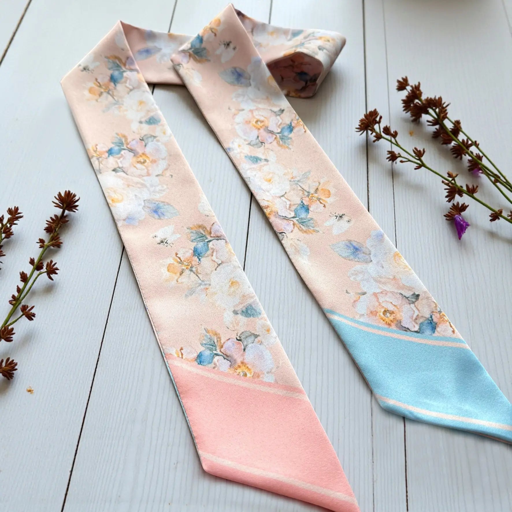 Elegant skinny scarf featuring romantic floral pattern in pastel blush and blue colour palette