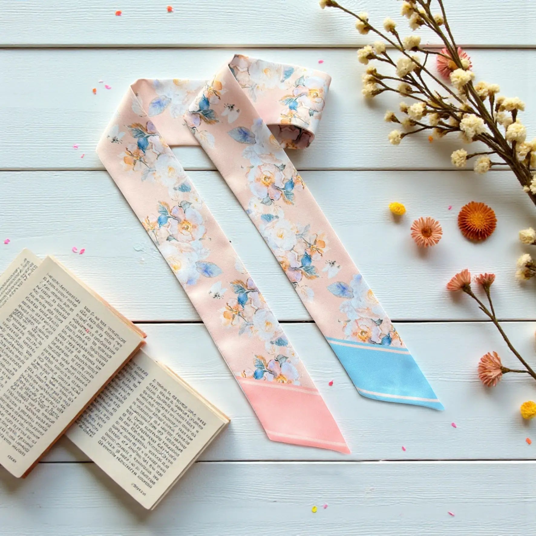 Elegant twilly scarf with soft pastel floral pattern in blush pink and light blue tones