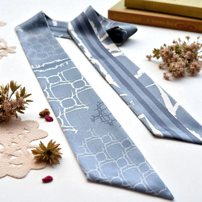 Skinny twilly scarf featuring abstract geometric shapes and stripe detail in muted blue colour palette