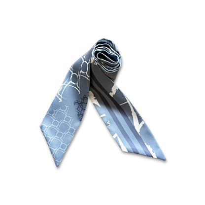 Minimalist skinny scarf in light blue with geometric pattern and soft stripe accents