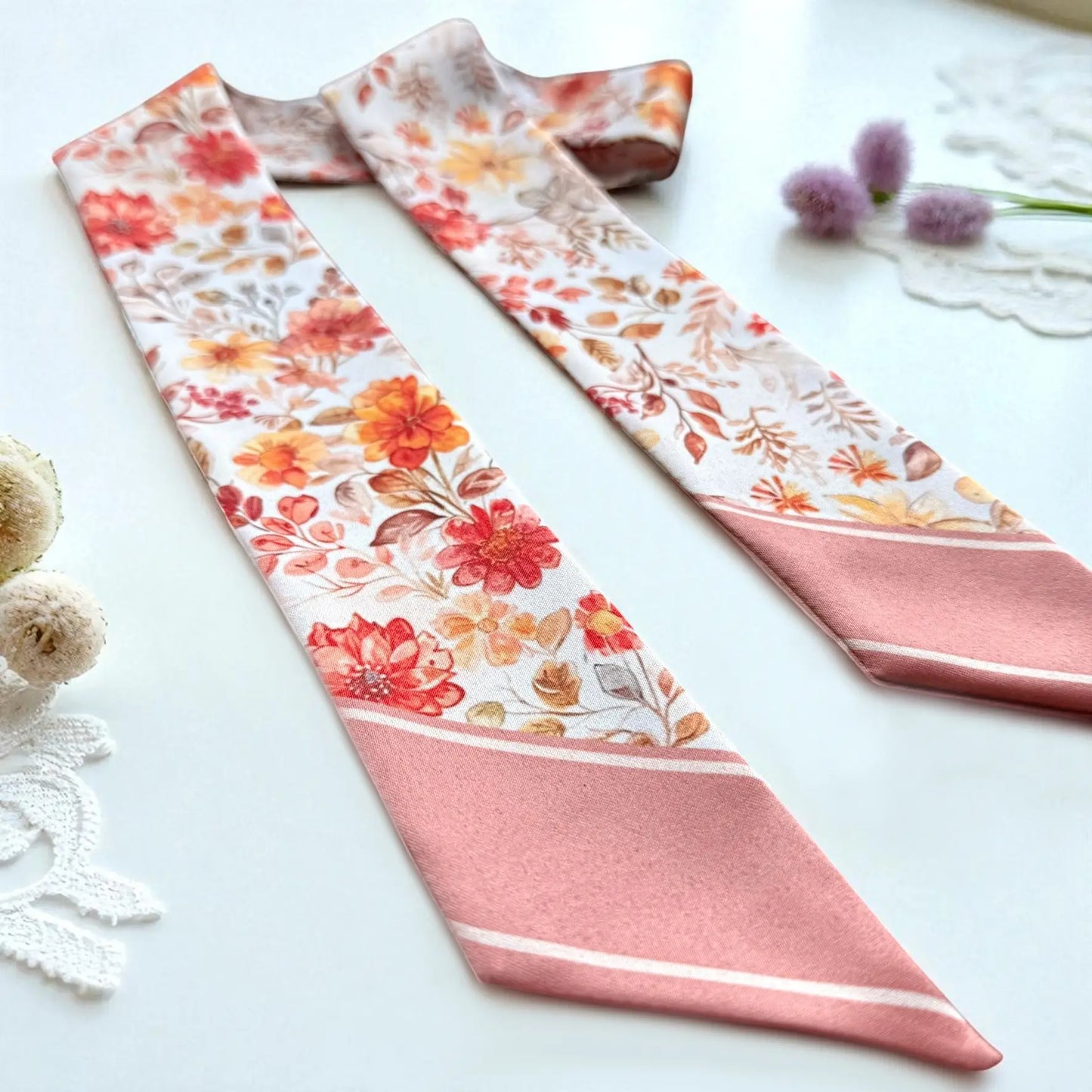 Skinny twilly scarf featuring delicate floral print in pastel orange palette for handbag styling