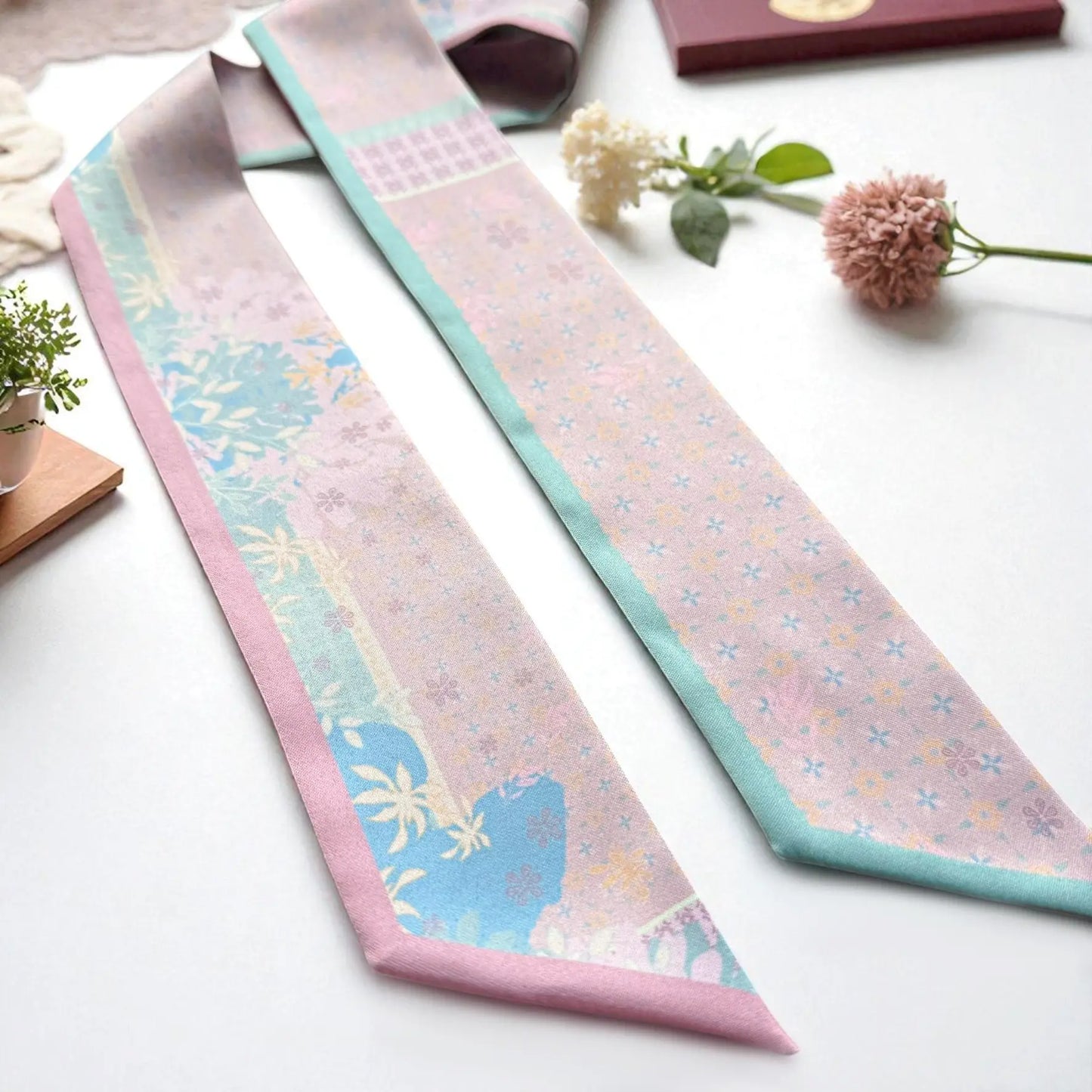 Elegant skinny scarf featuring delicate floral and subtle repeating pattern in pastel palette