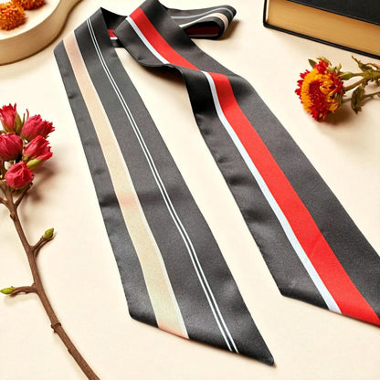 Minimalist black skinny scarf with contrasting red and white stripe pattern.
