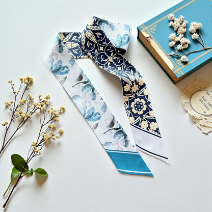 Personalized skinny scarf in elegant blue tones featuring ornamental floral detailing and soft botanical accents on a satin finish.