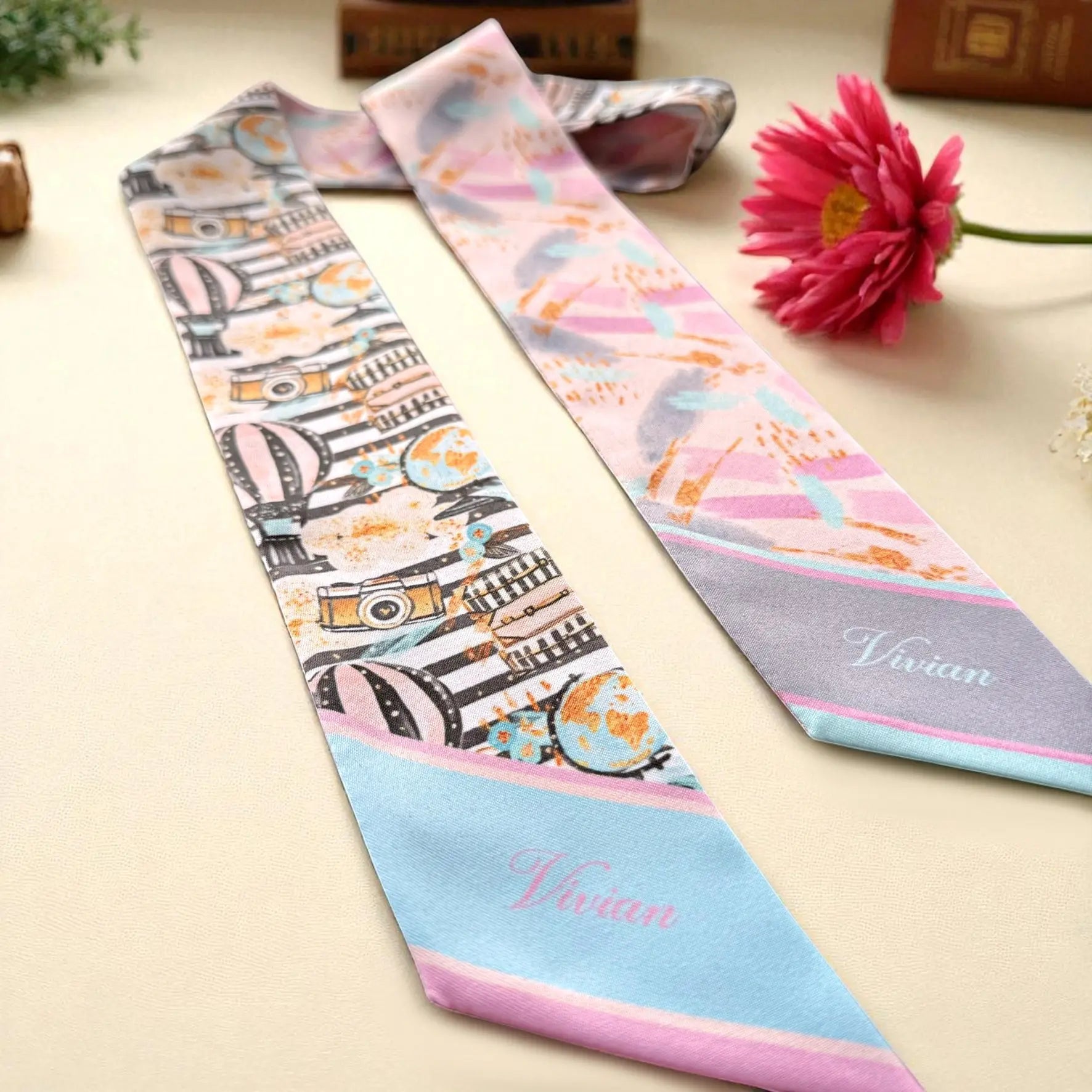 Elegant satin skinny scarf showcasing illustrated travel elements, soft pastel colors, and a luxurious double-sided finish.
