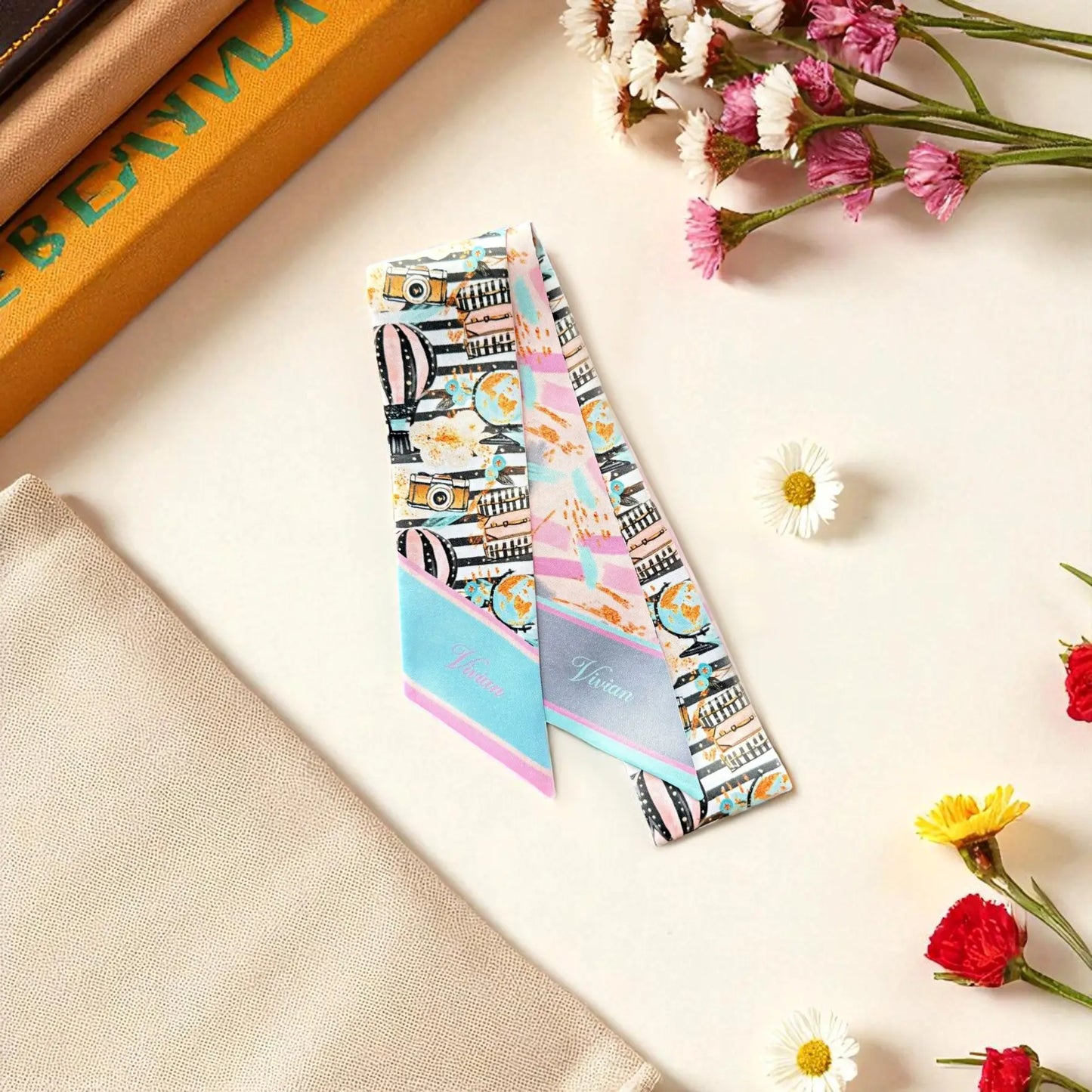 Double-sided twilly scarf with playful cityscape and travel motif on one side, paired with soft abstract pastel brushstroke design.