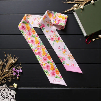 Pink garden floral twilly scarf featuring colourful blooms, citrus accents and delicate butterflies on a soft blush background