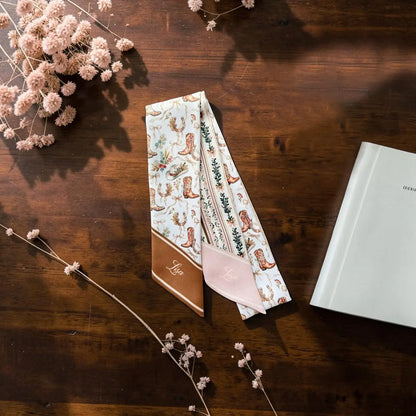 Feminine western skinny scarf featuring cowboy boot print and delicate botanical motifs