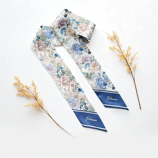 Personalised satin twilly scarf featuring vintage-inspired blue, lavender, and blush pink flowers with delicate green foliage on an ivory background, finished with navy blue pointed ends.
