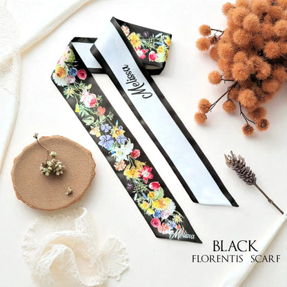 Black personalised skinny scarf with vibrant watercolour roses, daisies, and wildflowers, featuring a white reverse side with custom lettering.